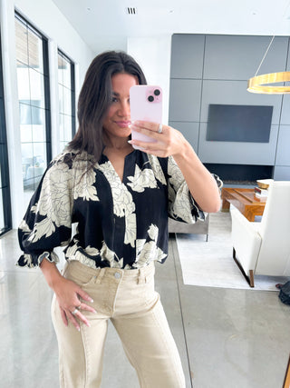 Flowy black blouse with oversized floral print and ruffle sleeve detail