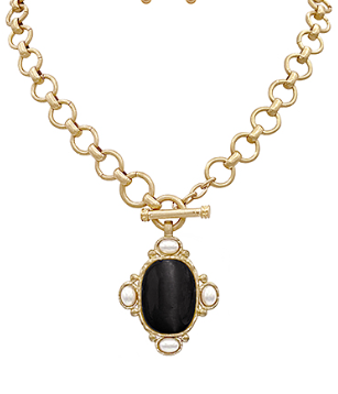 Gold chain necklace with black stone pendant framed in pearl-like accents; toggle clasp.